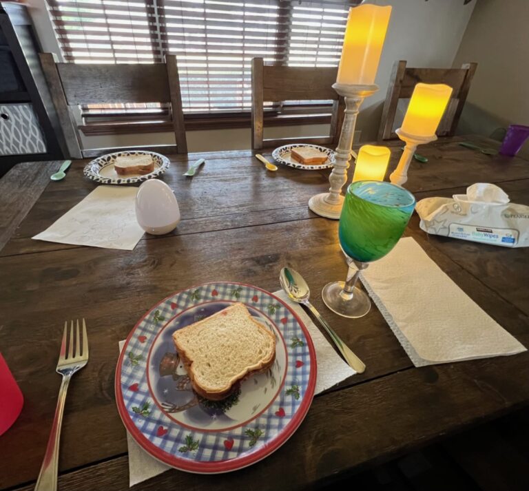 Table with three plates of PB&J sandwiches, color photo