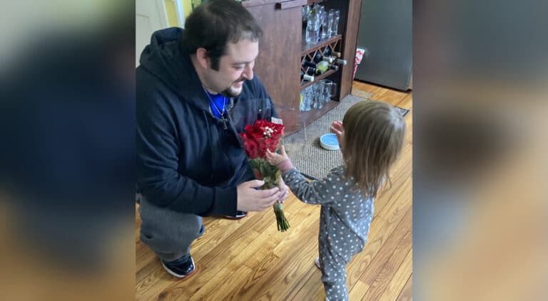 Dad giving young daughter flowers