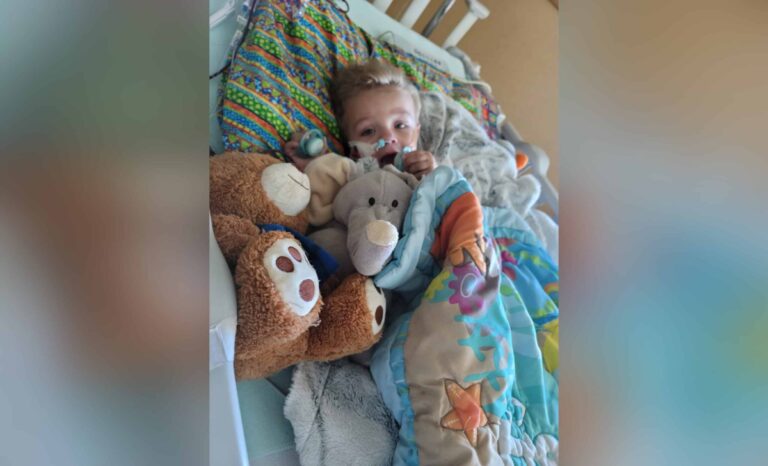 Toddler boy lying in hospital bed, color photo