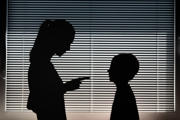 Silhouette of mother pointing finger at child