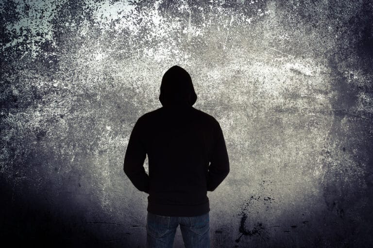 Teen in hoodie against black and white background