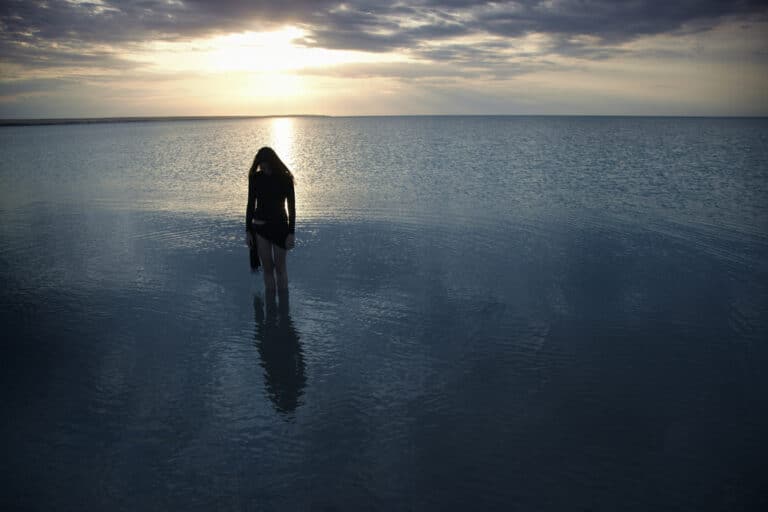 Woman in water at sunset