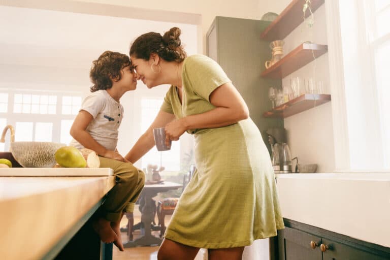 Mom and child in kitchen touch foreheads