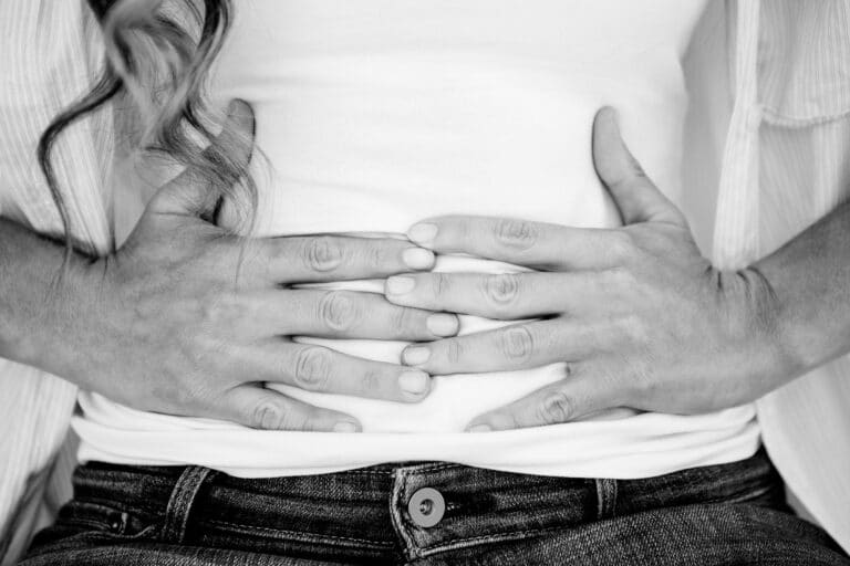 Woman's hands on stomach, black and white