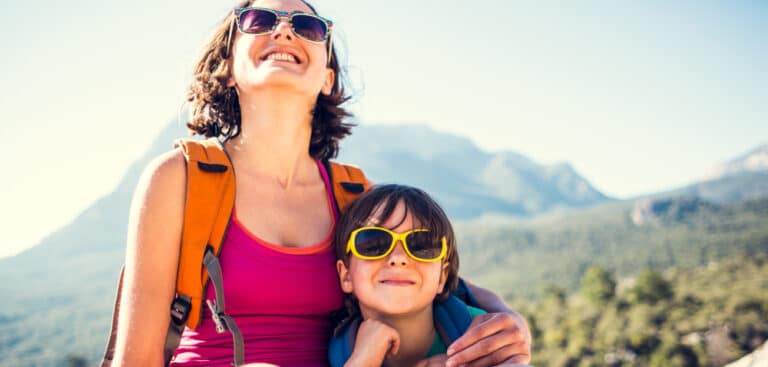 Mother and daughter smiling outside wearing sunglasses
