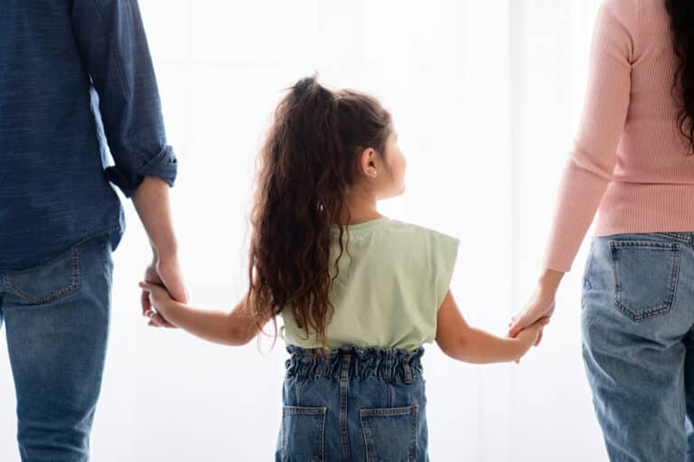 Girl holding parents' hand