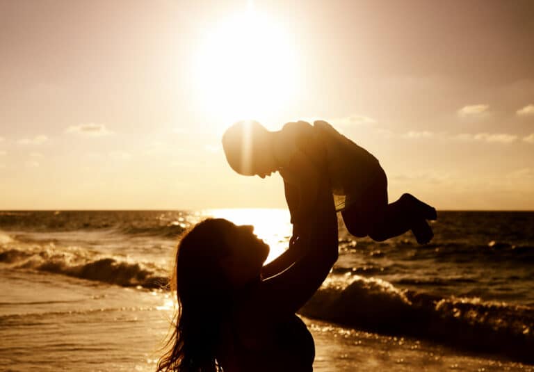 Mother holding up child silhouette