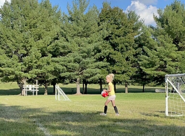 Little girl playing goalie at soccer practice, color photo