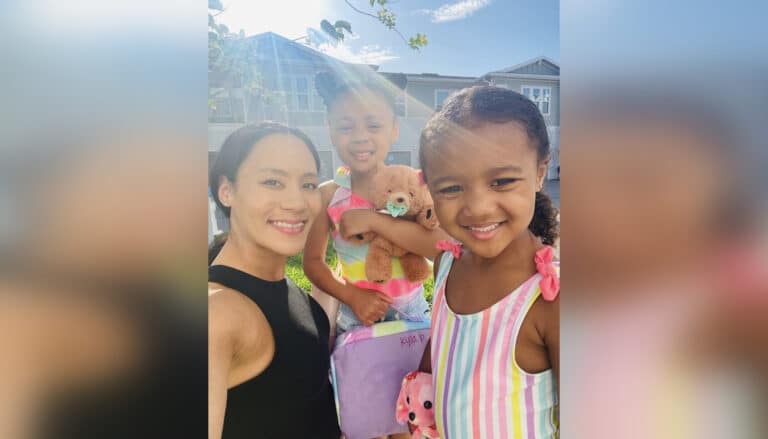 Mom and two young daughters in swimsuits smiling in summer selfie