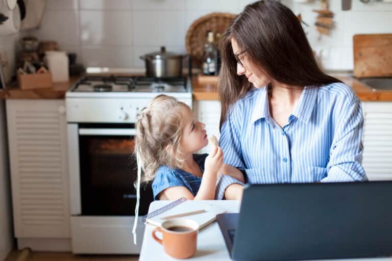 Working mom with daughter in kitchen at home