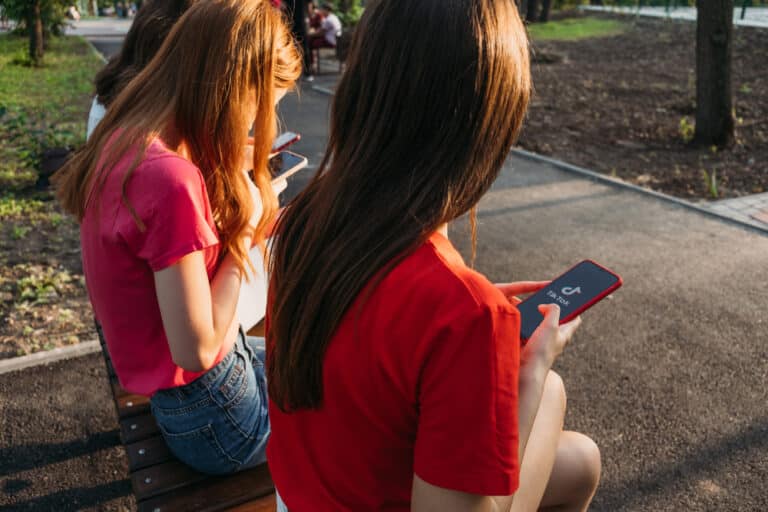 Teen girls holding smartphones using TikTok