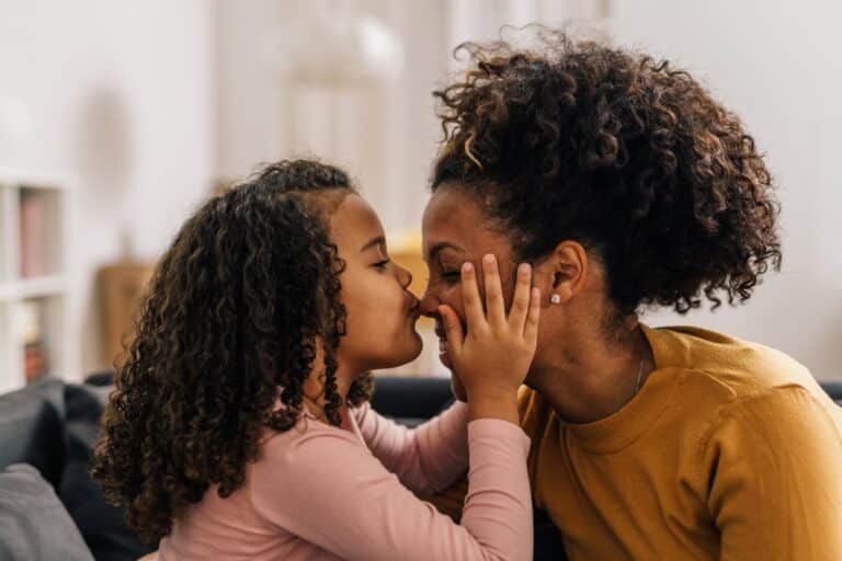 Daughter kisses mother on her nose