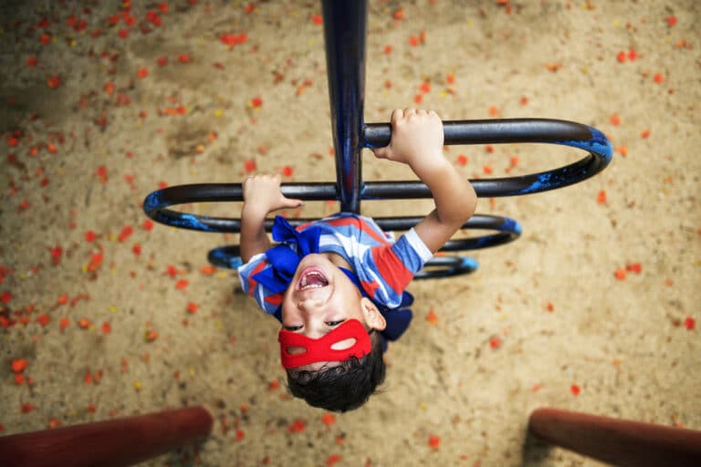 Little boy climbing playground equipment