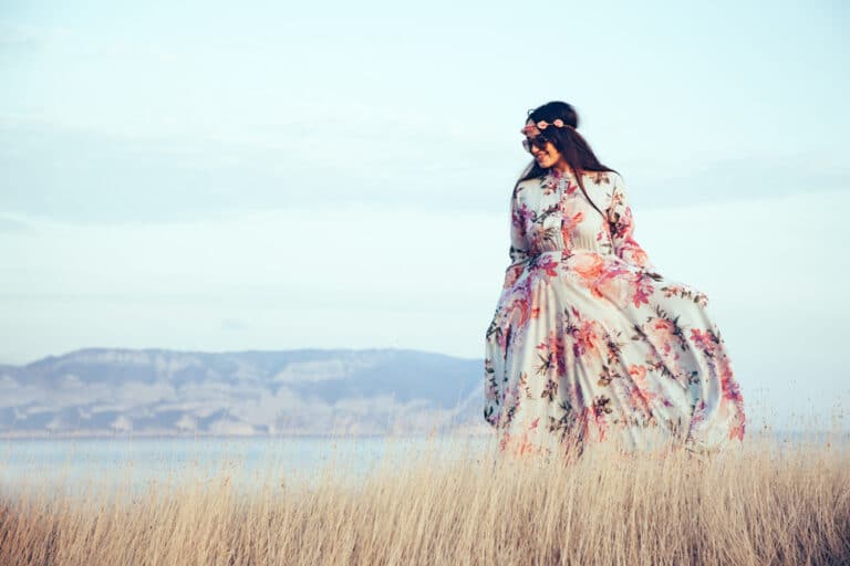 Woman standing in field wearing floral dress