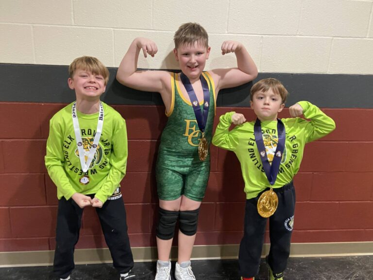 Three young boys with wrestling medals, color photo