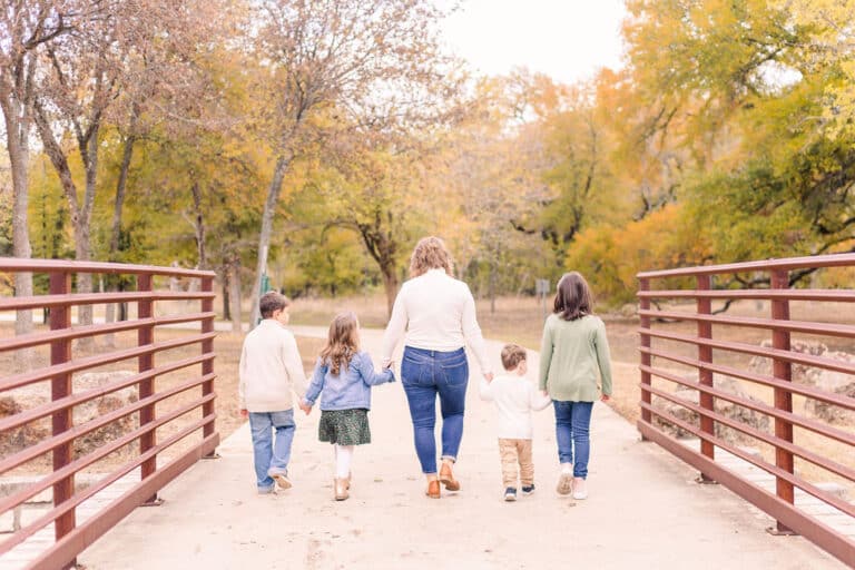 Mother and four children walking, color photo