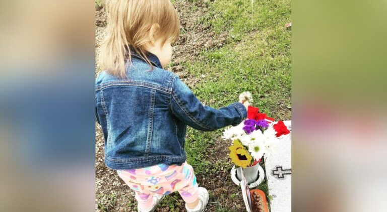 Toddler girl at cemetery, color photo