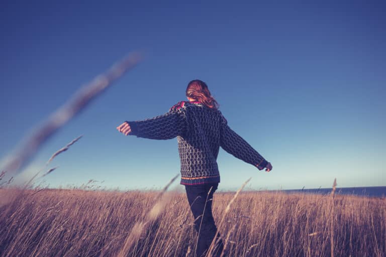 Girl with arms out in field