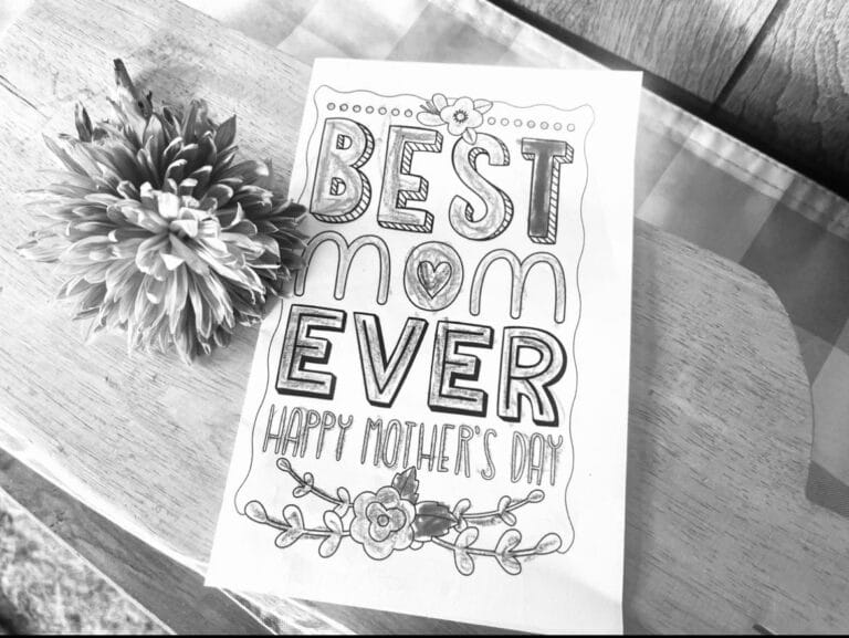 Black and white image of "Best mom ever" card and flower