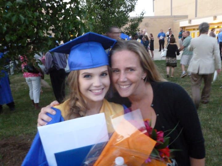 Mother standing with high school graduate