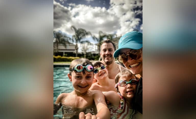 Husband, wife, three kids in a pool, color photo