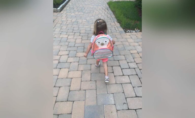 Little girl with backpack, color photo