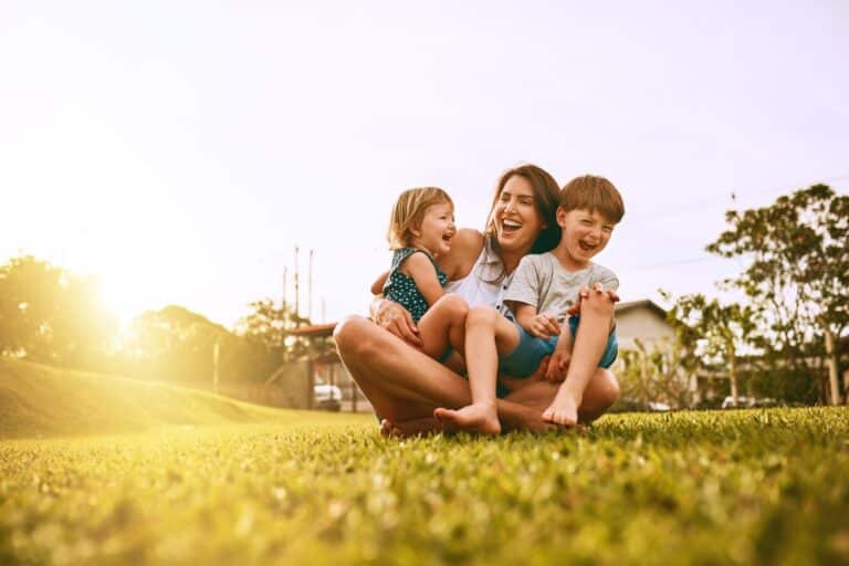 Mom with son and daughter laughing outside