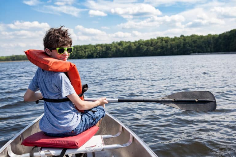 Tween boy rowing in canoe facing backward