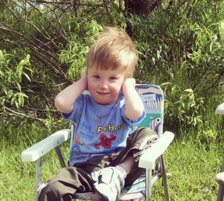 Little boy sitting in lawn chair, color photo