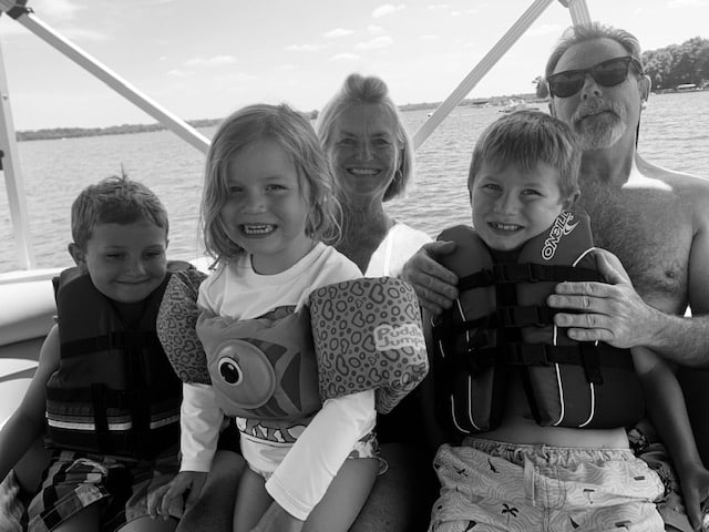 Three kids on a boat with grandma and grandpa, black-and-white photo