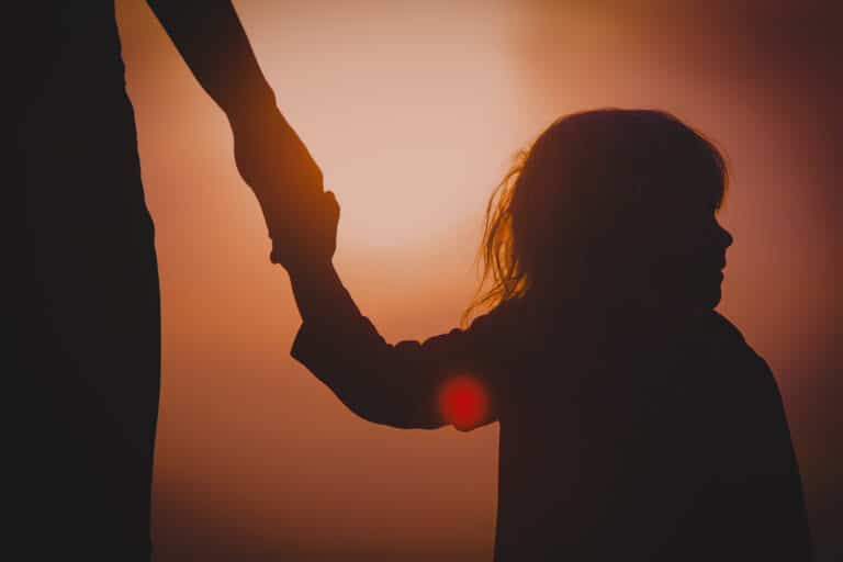 Mother holding little girl's hand, silhouette