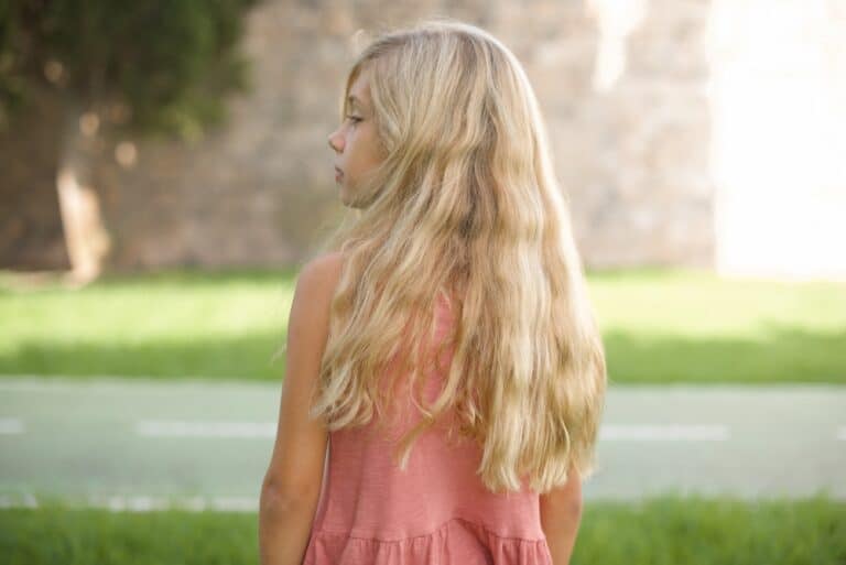 Back view of a blonde young girl looking to the side