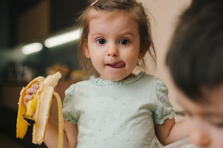 Toddler girl holding a banana