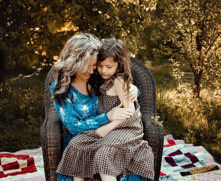 Mother holding daughter outside, color photo