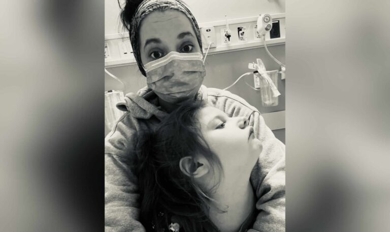 Mother in mask holding child in hospital, black-and-white photo