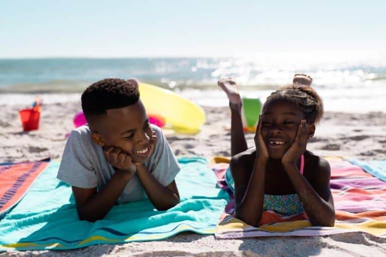 Kids on beach blankets smiling