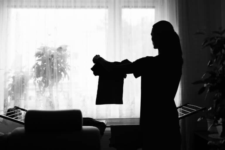 Mother holding up small clothes silhouette in window