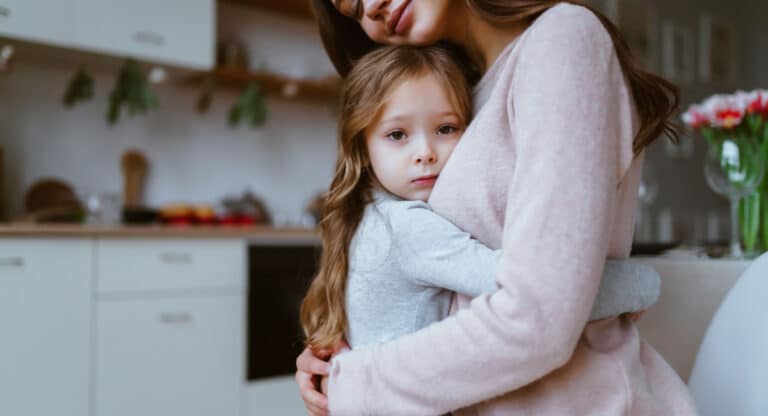 Mother hugging toddler daughter in kitchen