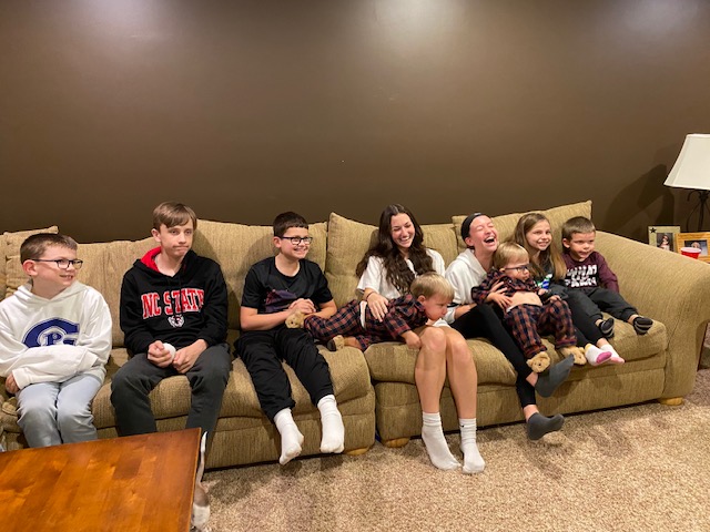 Nine children sitting on a couch together