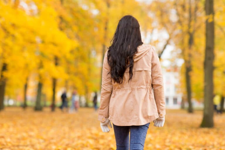 Woman walking down autumn path