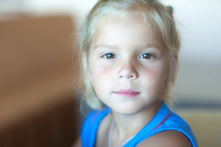 Portrait of a beautiful little girl in blue shirt