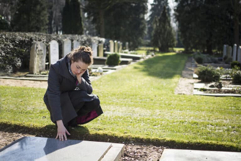 Woman kneeling at grave