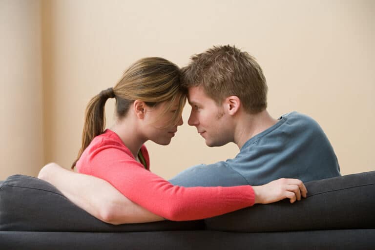 Couple touching foreheads sitting on couch