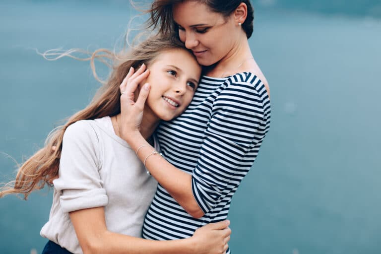Mother and teen daughter hug
