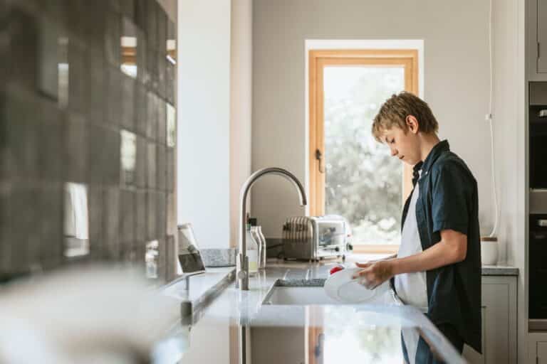 Teen boy washing dishes