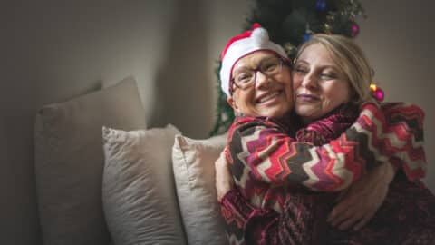 Woman and mother embrace in Christmas outfits