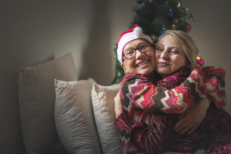 Woman and mother embrace in Christmas outfits