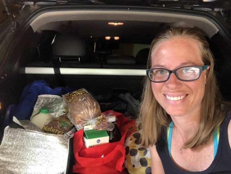 Woman with a load of groceries in the back of her van, color photo