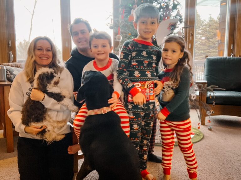 Family in pajamas near Christmas tree, color photo