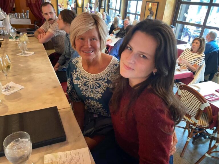 Mother and grown daughter at restaurant, color photo